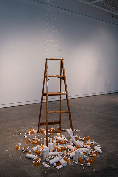 HOMAGE, installation of wooden ladder surrounded by plastic empty pill bottles and ceramic simulacra pill bottles by Susan Mollet